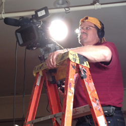 dave waldman on ladder with video camera